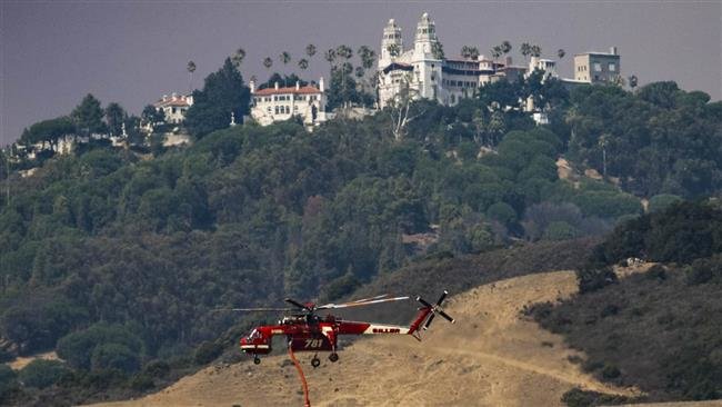 Một trực thăng đang bay tới khu San Simeon, California để chống cháy rừng - Ảnh: AP