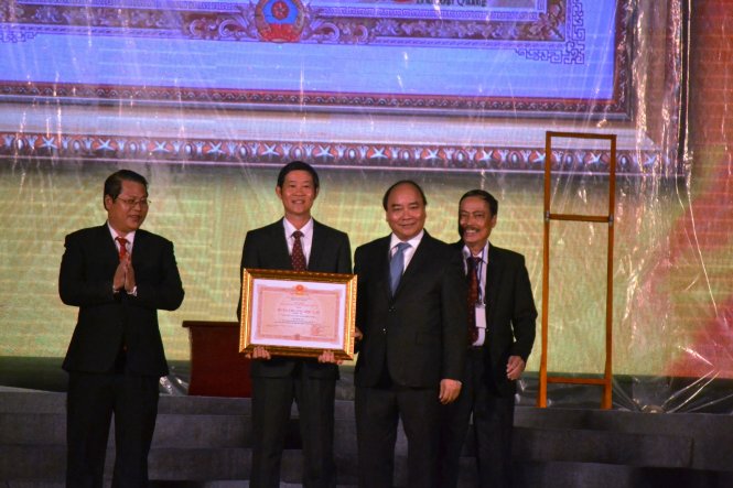 Thủ tướng Nguyễn Xuân Phúc trao chứng nhận huân chương độc lập hạng 3 cho lãnh đạo TP Tam Kỳ. Ảnh: LÊ TRUNG