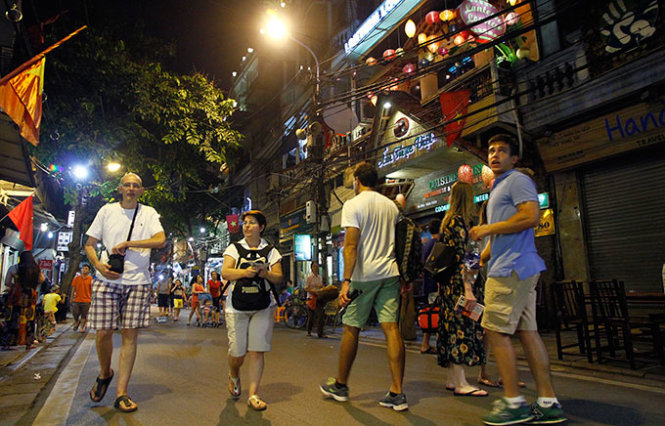 Du khách nước ngoài dạo chơi đêm tại khu phố cổ Hà Nội - Ảnh: NAM TRẦN