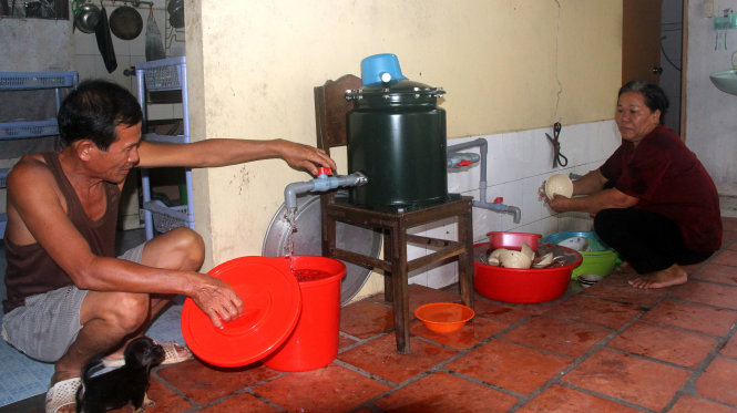 Người dân ở xã Tân Thông Hội, huyện Củ Chi sử dụng nước thông qua thiết bị lọc nước hộ gia đình được lắp thí điểm tháng 7-2015 - Ảnh: QUANG KHẢI