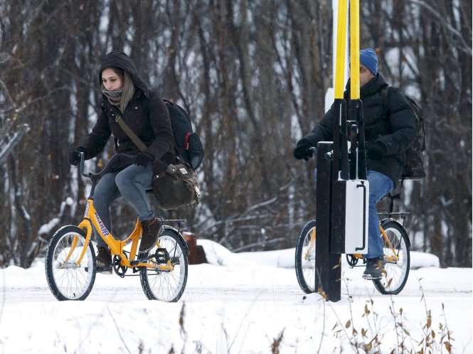 Hai người tị nạn đang đi xe đạp vượt qua biên giới giữa Na Uy và Nga ở vùng bắc cực - Ảnh: AFP