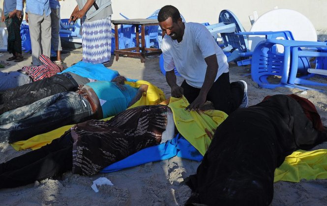 Một người đàn ông khóc bên cạnh các thi thể trên bãi biển Lido sau cuộc tấn công - Ảnh: AFP