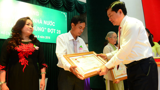 Bí thư Thành ủy TP.HCM Đinh La Thăng trao tặng danh hiệu Bà Mẹ VN Anh hùng cho đại diện gia đình các bà mẹ trong lễ truy tặng đợt 28 sáng 31-8 - Ảnh: QUANG ĐỊNH