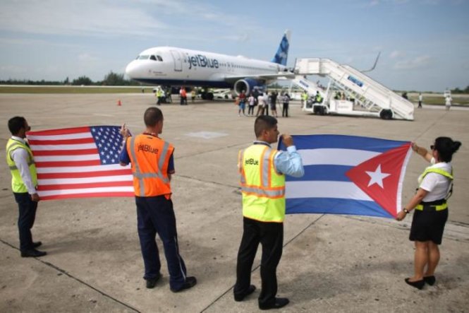 Nhóm nhân viên mặt đất ở sân bay tại Santa Clara, Cuba chăng cờ Mỹ và cờ Cuba chúc mừng sự kiện chuyến bay thương mại đầu tiên từ Mỹ tới Cuba - Ảnh: Reuters