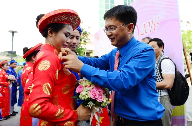 Ông Nguyễn Mạnh Cường, Bí thư Thường trực Thành Đoàn trao huy hiệu cho các cặp đôi trong đám cưới tập thể - Ảnh: DUYÊN PHAN