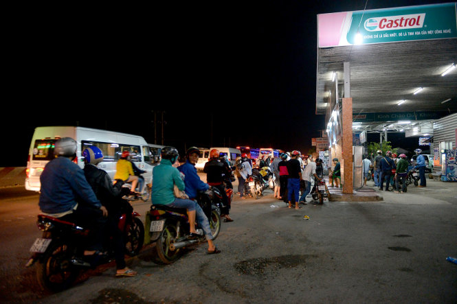 Người dân xếp hàng dài chờ đổ xăng tại một trạm xăng trên quốc lộ 1A đoạn qua tỉnh Tiền Giang - Ảnh: HỮU KHOA