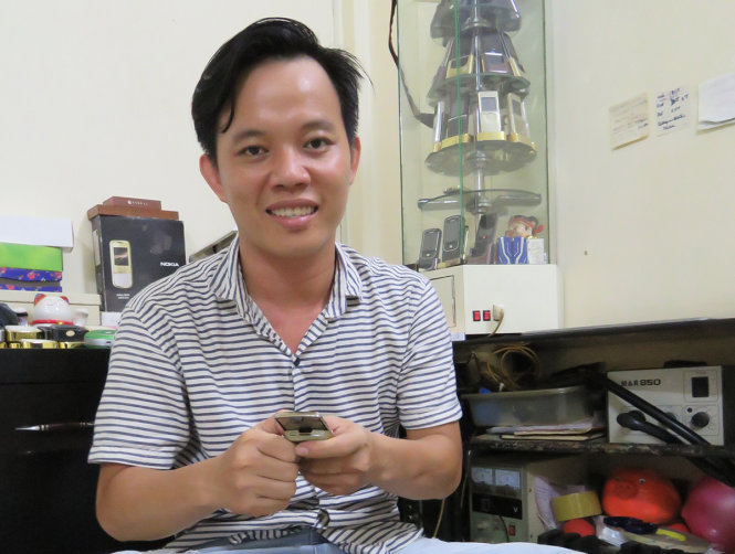 Anh Dương Trọng Tiến vui vẻ và an tâm với công việc sửa chữa, bán điện thoại cũ - Ảnh: ÁI NHÂN