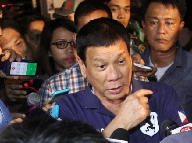 Các phóng viên phỏng vấn tổng thống Philippines, ông Rodrigo Duterte, sau khi ông tới thị sát hiện trường vụ nổ tại một khu chợ ở thành phố Davao, Philippines ngày 3-9 - Ảnh: Reuters