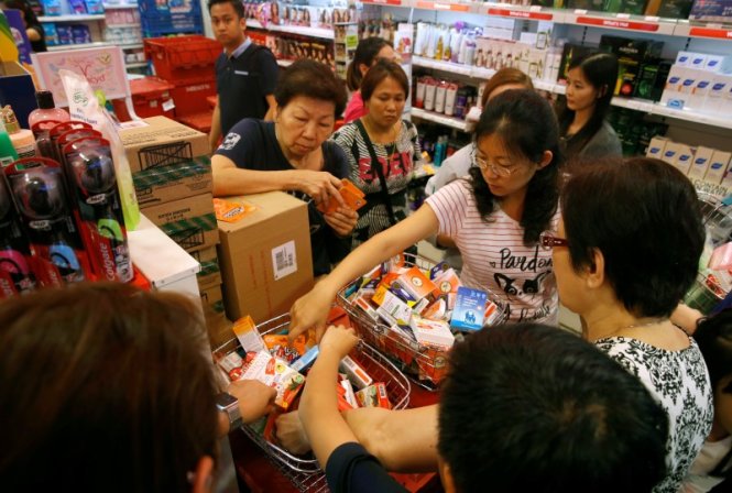 Người dân đổ xô mua sản phẩm chống muỗi ở Singapore ngày 2-9 - Ảnh: Reuters