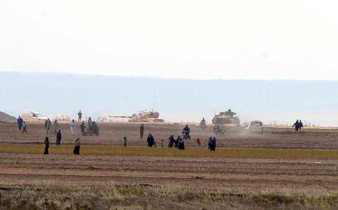 Người dân Syria bỏ chạy khi xe tăng của Thổ Nhĩ Kỳ vượt biên giới từ tỉnh Kilis - Ảnh: Reuters
