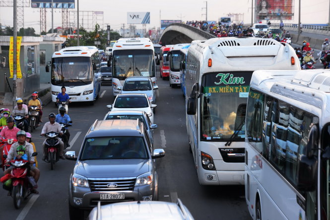 Xe ô tô khách, xe máy ùn ứ kéo dài khu vực cầu vượt Nguyễn Văn Linh - Ảnh: HỮU KHOA
