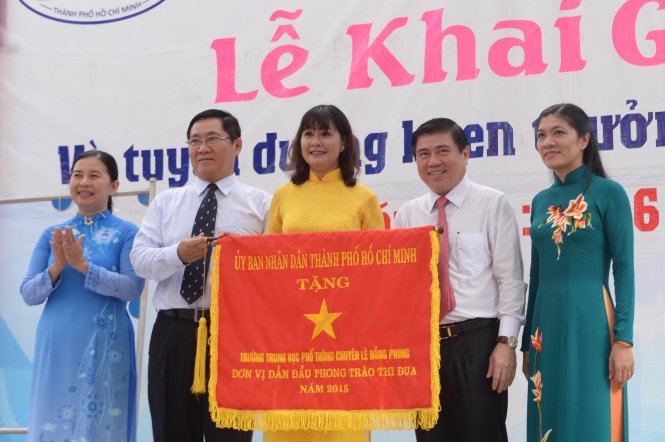 Chủ tich UBND.TP.HCM Nguyễn Thành Phong (thứ hai, từ phải sang) tặng cờ thi đua của thành phố cho trường THPT chuyên Lê Hồng Phong trong ngày khai giảng - Ảnh: Tự Trung