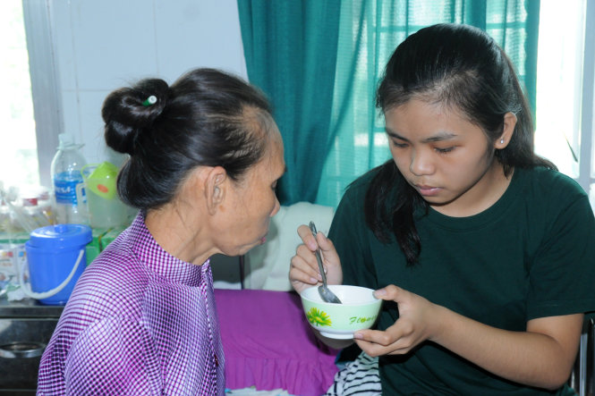 Tân sinh viên Nguyễn Thị Quỳnh Như chăm mẹ tại Bệnh viện Đa khoa khu vực Định Quán - Ảnh: A LỘC