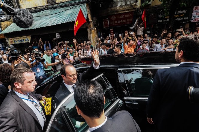 Tổng thống Pháp Francois Hollande vẫy tay chào người dân khi lên xe rời phố cổ