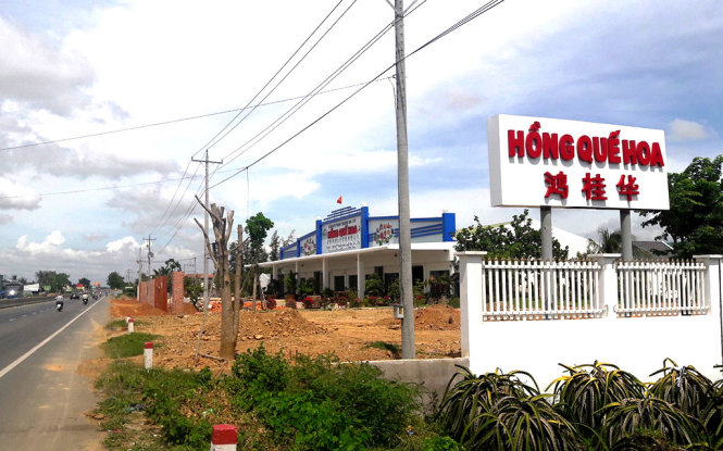 Vựa thanh long Hồng Quế Hoa ghi tiếng Trung Quốc và tiếng Việt lấn hành lang an toàn đường bộ đến 11 mét - Ảnh: NG.NAM