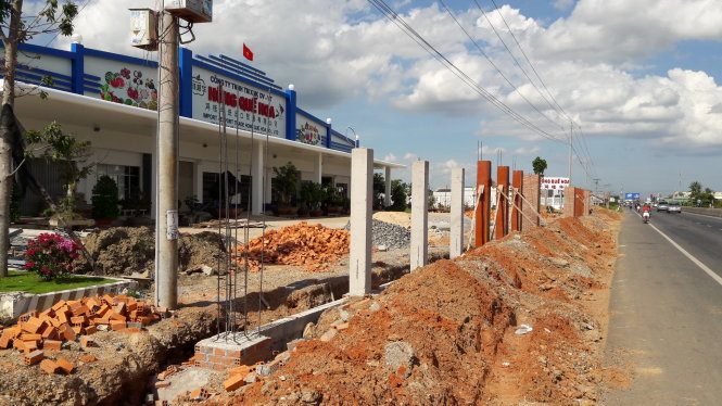 Cổng và hàng rào vựa thanh long xây trái phép nằm sát nền đường nhựa quốc lộ 1 - Ảnh: NG.NAM