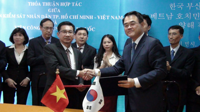 Đại diện VKSND TP.HCM, ông Dương Ngọc Hải (bìa trái) và đại diện Viện công tố Busan, ông Hwang Cheol Kyu ký thỏa thuận - Ảnh: TUYẾT MAI