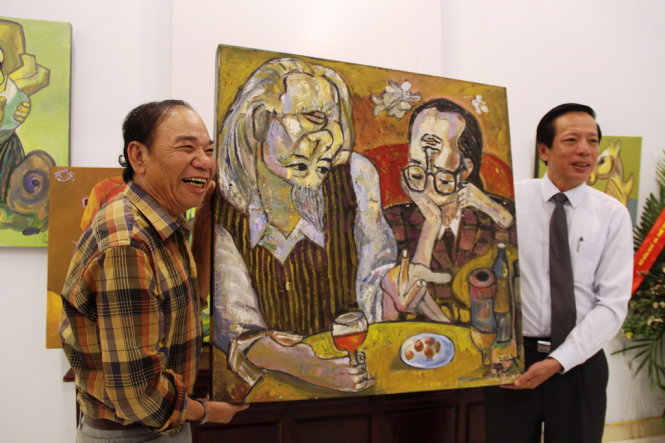 Ông Phan Tiến Dũng, giám đốc Sở Văn hóa, thể thao Thừa Thiên - Huế (phải) tiếp nhận tranh từ họa sĩ Nguyễn Đại Giang. Ảnh: MINH AN