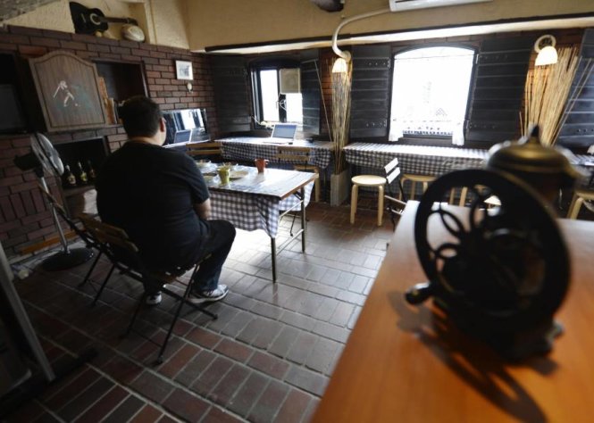 Một người trẻ Nhật thường chỉ ngồi một mình làm việc tại một quán cà phê ở Suita, tỉnh Osaka - Ảnh: Kyodo