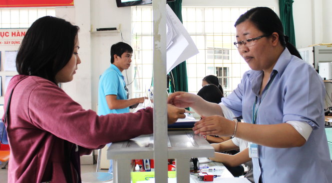 Chị Nguyễn Thị Trung Tính (phải) - chuyên viên UBND P.15 (Q.Bình Thạnh) - tiếp chuyện và hoàn trả hồ sơ cho người dân - Ảnh: Q.L.
