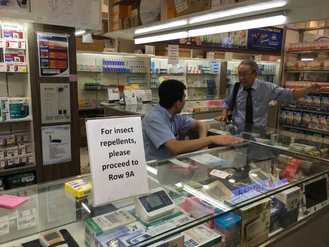 Quầy bán thuốc tại Mustafa Center phải để bảng thông báo để hạn chế trả lời lượng người dồn dập đến hỏi mua thuốc chống muỗi - Ảnh: LÊ NAM