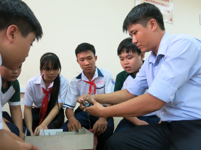 Thầy Sanh hướng dẫn học sinh lắp ráp các mạch điện tử - Ảnh: T.TRANG