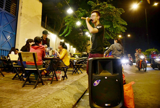 Những thanh niên hát bán kẹo kéo tại quán nhậu tạo ra âm thanh chói tai trên đường Phạm Văn Đồng, Q.Gò Vấp, TP.HCM - Ảnh: HỮU THUẬN