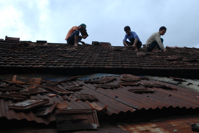 Các lực lượng thanh niên, dân quân xã Cam Tuyền, huyện Cam Lộ (Quảng Trị) được huy động để lợp lại mái nhà cho dân tại thôn Tân Hòa sau khi lốc xoáy quét qua – ảnh: Quốc Nam