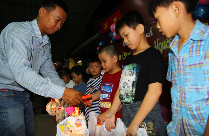 Ông Lê Trường Giang, giám đốc khu du lịch Vinh Sang trao quà cho con em người bán báo tại TP Cần Thơ tối 13-9 - Ảnh: CHÍ QUỐC