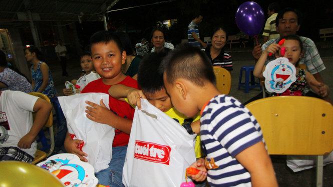 Trẻ em là con em người bán báo tại TP Cần Thơ vui mừng khi nhận được quà trung thu tối 13-9 - Ảnh: CHÍ QUỐC