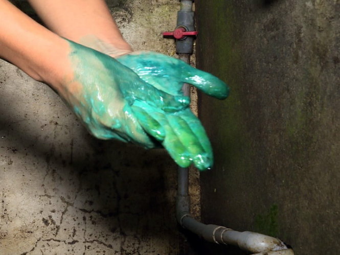 Hóa chất màu xanh dùng để pha với nước, ngâm rau muống dính vào tay rất khó tẩy rửa. Ảnh: Quỳnh Giang.