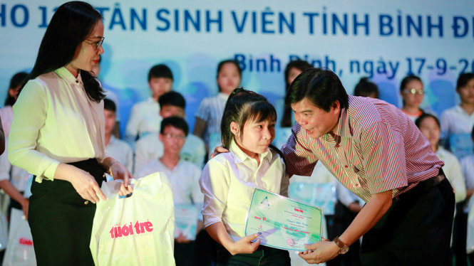 Ông Tăng Hữu Phong, tổng biên tập Báo Tuổi Trẻ (phải) và bà Nguyễn Thị Thơm, phó ban tuyên giáo tỉnh Bình Định (trái) trao học bổng “Tiếp sức đến trường” cho các tân sinh viên - Ảnh: TIẾN THÀNH
