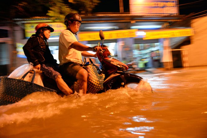 Nước ngập sâu gần đến yên xe trên đường Lê Văn Lương - Ảnh: HỮU KHOA