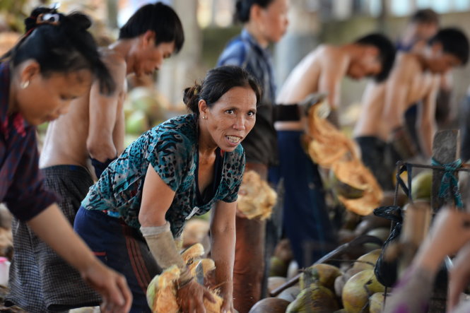 Cô Huỳnh Thị Thắm (56 tuổi) làm nghề lột vỏ dừa hơn 10 năm tại chợ  - Ảnh: Hữu Khoa