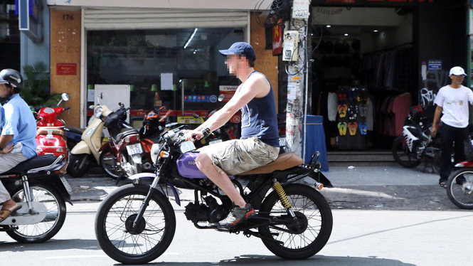 Một người nước ngoài không đội mũ bảo hiểm chạy xe máy trên đường Bùi Viện (Q.1, TP.HCM) - Ảnh: NGỌC DƯƠNG