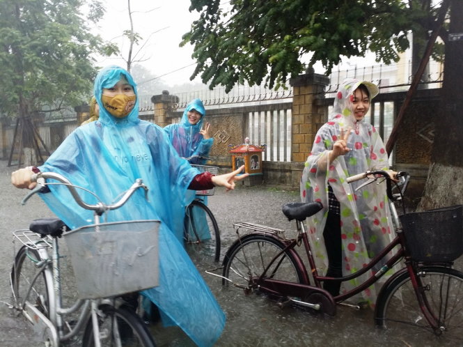 Một nhóm sinh viên của trường ĐH Khoa học - ĐH Huế phải dắt bộ xe đạp vì đường ngập - Ảnh: NHẬT LINH
