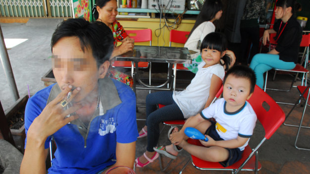 Trẻ em, phụ nữ thường phải hít khói thuốc lá thụ động tại các quán giải khát - Ảnh: Hoàng Thạch Vân