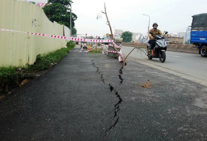 Hai vết nứt chạy dài gần 20 mét tại vị trí đường vừa được tái lập trên quốc lộ 1A đoạn qua quận 9, TP.HCM - Ảnh: LÊ PHAN