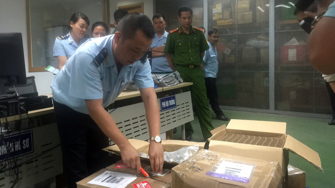 Lực lượng chức năng đang kiểm tra lô hàng tinh dầu nhập không phép về Việt Nam - Ảnh: Thân Hoàng