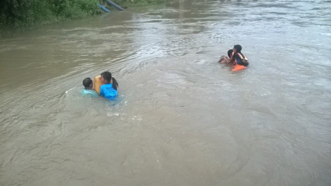 Cảnh học sinh, phụ huynh bơi qua sông Bà Đài để về nhà sau giờ tan trường chiều 20-9 - Ảnh: ĐẶNG NGỌC THÀNH