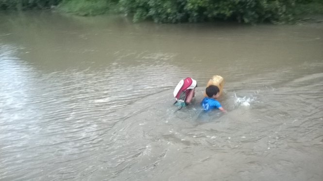 Cảnh học sinh, phụ huynh bơi qua sông Bà Đài để về nhà sau giờ tan trường chiều 20-9 - Ảnh: ĐẶNG NGỌC THÀNH