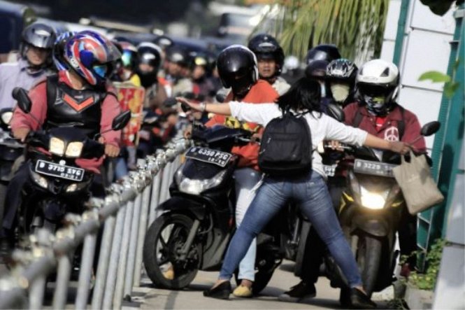Cô Alfini Lestari chặn xe máy do kẹt xe đã chạy lên lề đường ở Jakarta - Ảnh: Jakarta Post