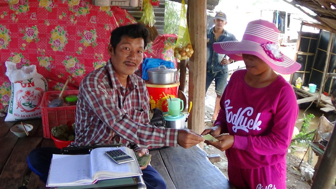 Anh Trung trả tiền Cua cho một người Campuchia mới vừa cân xong - Ảnh: Bửu Đấu