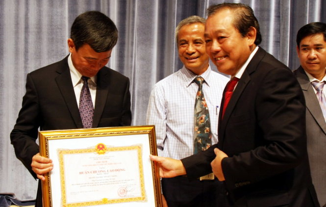 Phó thủ tướng thường trực Chính phủ Trương Hòa Bình trao Huân chương Lao động hạng nhất cho lãnh đạo Trường ĐH Tôn Đức Thắng sáng 24-9 - Ảnh: TRẦN HUỲNH