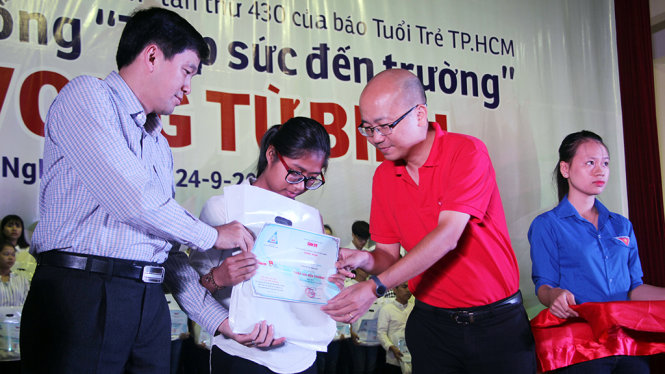 Ông Dương Đức Đà Trang, Trưởng văn phòng đại diện miền Bắc báo Tuổi trẻ trao học bổng cho tân sinh viên - Ảnh: DOÃN HÒA