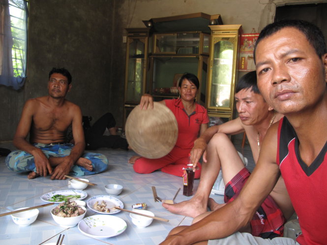 Bữa cơm trưa nhà anh Hoàng Văn Thiên gần bãi rác phải vừa ăn vừa quạt ruồi         - Ảnh : DUY KHÁNH