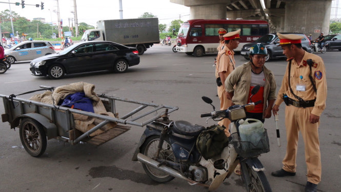 Trong buổi sáng, đã có hàng chục trường hợp xe máy gắn móc kéo chở theo hàng hóa bị lực lượng CSGT xử phạt - Ảnh: HOÀI NAM