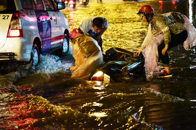 Một cô gái bị té ngã giữa dòng nước trên đường Trường Sơn - Ảnh: HỮU THUẬN