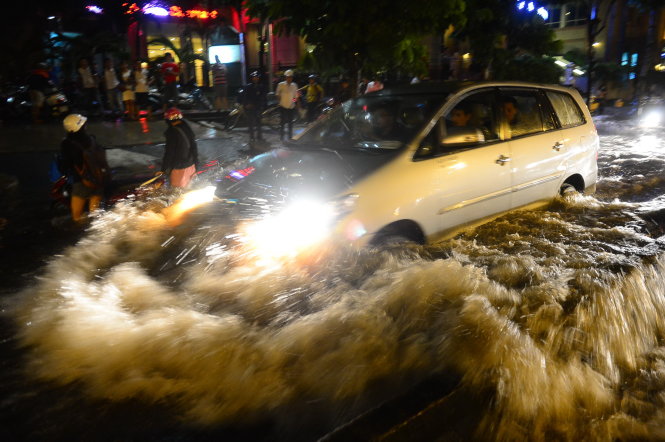 Một xe ôtô phóng nhanh trong nước ngập trên đường Nguyễn Hữu Cảnh, Q. Bình Thạnh, TP.HCM tối 26-9 - Ảnh: QUANG ĐỊNH