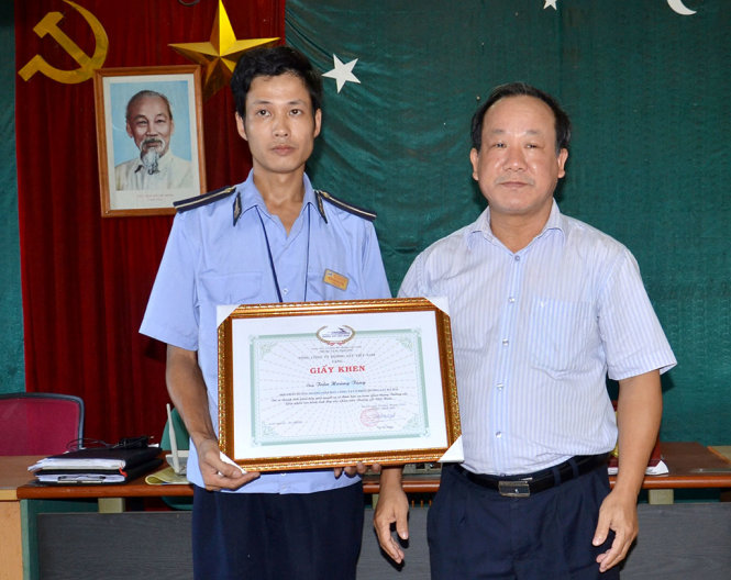 Anh Trần Hoàng Tùng nhận giấy khen từ Phó tổng giám đốc Tổng công ty Đường sắt Việt Nam Đoàn Duy Hoạch - Ảnh: TRANG NHUNG